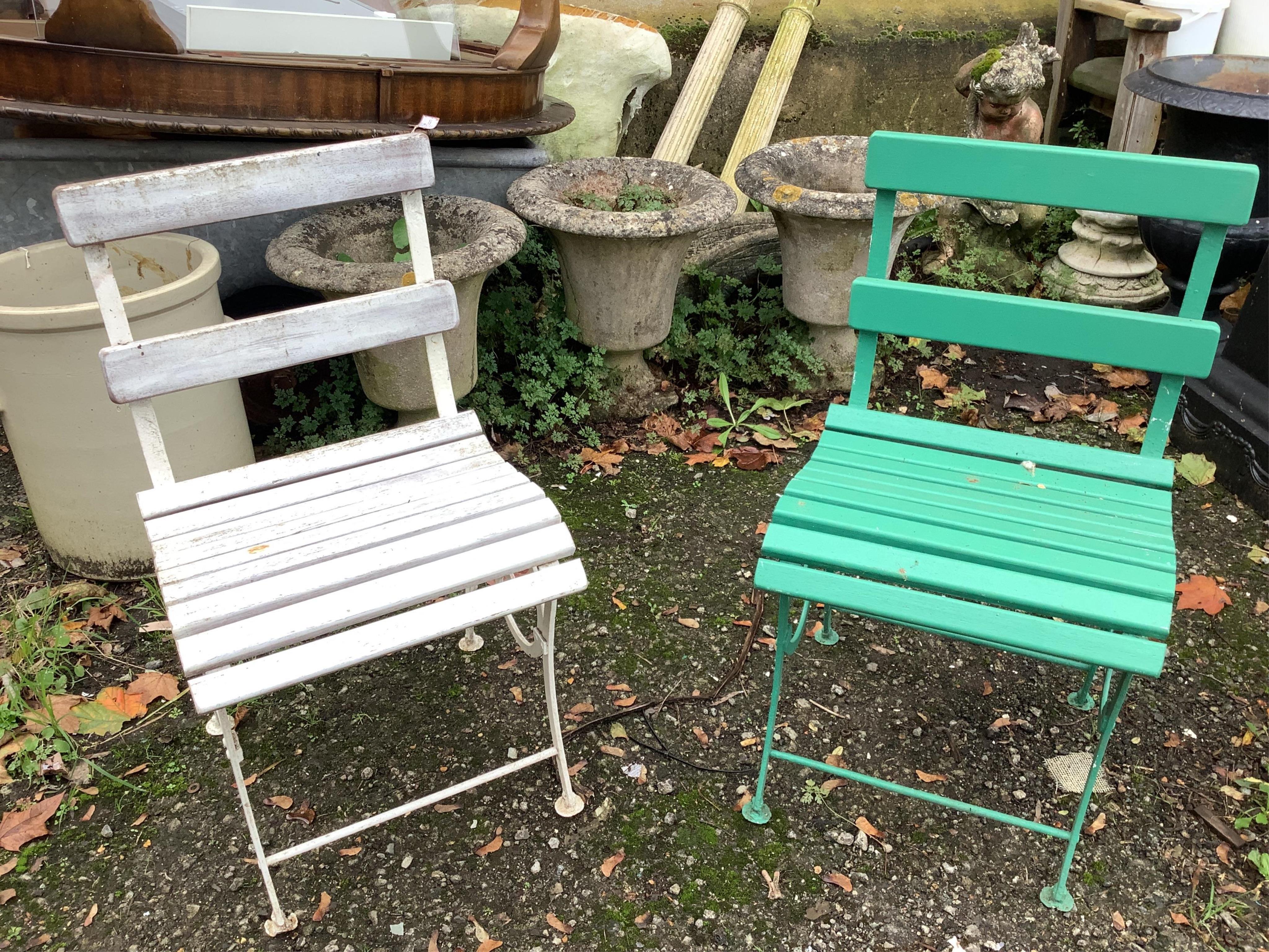 A slatted teak wrought iron garden bench, width 155cm and a pair of similar painted chairs. Condition - some paint loss, otherwise fair